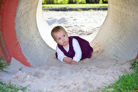 The little child playing in the sandbox on the playgroundの写真素材