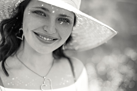 Monochrome portrait of beautiful girl in straw hat on bright dayの写真素材