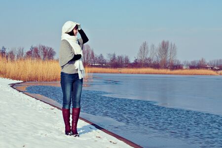 Pretty girl walking at winter lakeの写真素材
