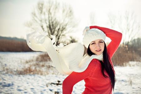 Outdoor portrait of a young woman in winter with flying scarfの写真素材