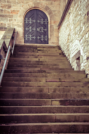 Wooden old door with wrought-iron elements and stepsの写真素材