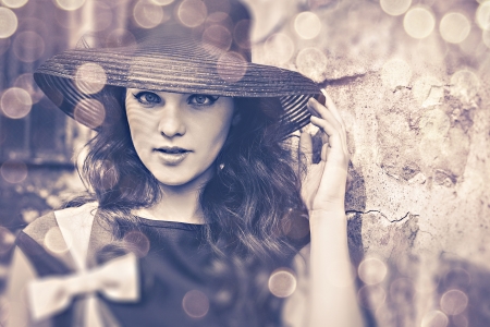 Elegant young woman in black hat in the old townの写真素材
