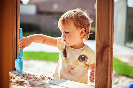 Child playing with sand on the playgroundの写真素材