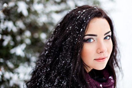 Woman with snowy brown hair in forestの写真素材