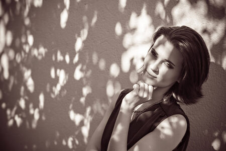 Pretty woman standing in shadow of tree