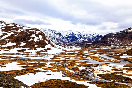 Snowy surface of mountain and small riverの写真素材