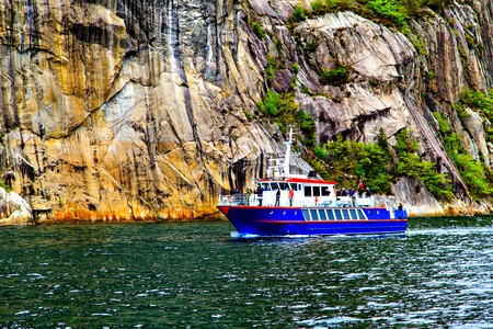 The blue ship on background of majestic cliffsの写真素材