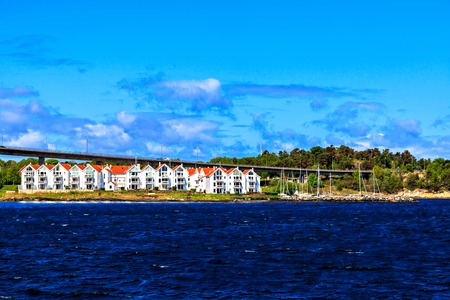 A line of white two-story houses near the harborの写真素材