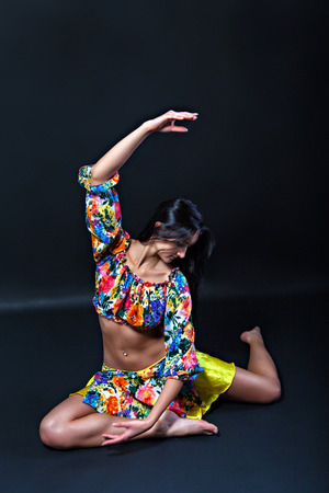 Pretty brunette woman in colorful costume dancingの写真素材