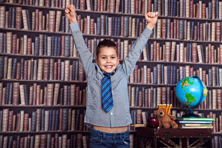 First-grader boy with her hands raised, rejoices school and a good estimate