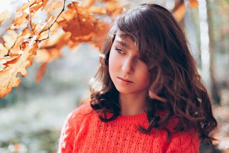Portrait of young girl with long hair in the autumn forestの写真素材