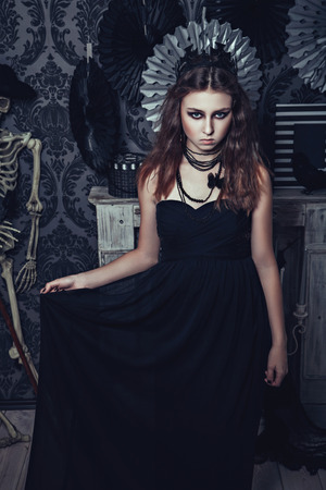 Brunette young girl in the image of queen with crown - Halloween styleの写真素材