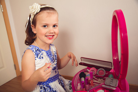 Little girl making makeup on the beauty tableの写真素材