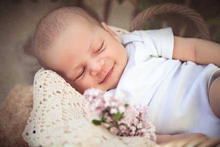 Cute newborn baby sleeping in the basketの写真素材