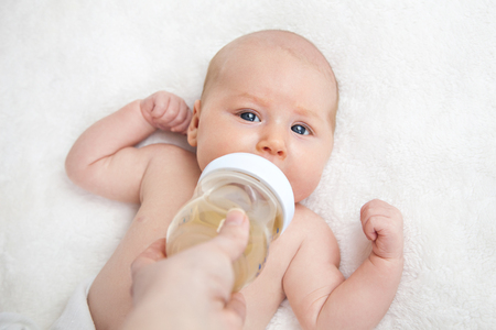 Mother feeding newborn baby from the bottleの写真素材