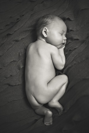 Baby girl lying on a bed while sleepingの写真素材