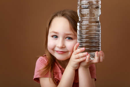 Little girl hugging a bottle of waterの写真素材