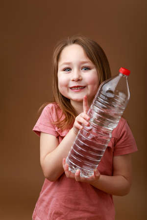 Little funny girl with a bottle of waterの写真素材