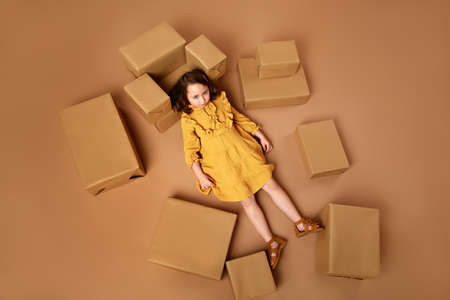 Little curly girl with a big stack of gifts for the holidayの写真素材