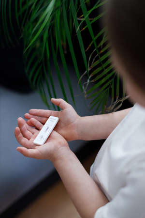 Kid girl with test strip for antibody or sars-cov-2 virus disease in handsの写真素材