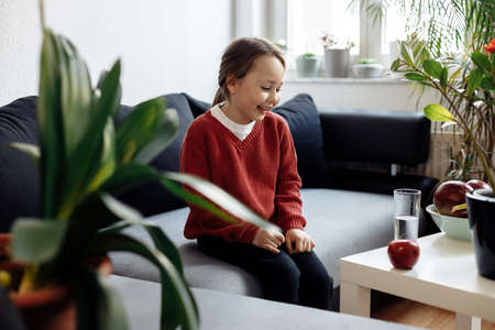 Healthy eating - child looking to water and fruits, lots of fresh fruit on the table in front at home, healthy lifestyle conceptの写真素材