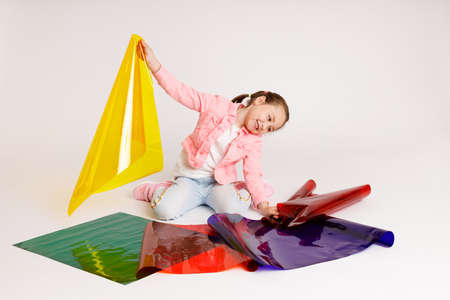 Preschool girl learning colors and their combinations using colored foil, early development and learning concept.の写真素材