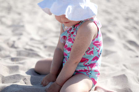 Little happy girl on white sand beach enjoying summer and vacation.の写真素材