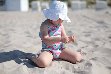 Little happy girl on white sand beach enjoying summer and vacation.の写真素材