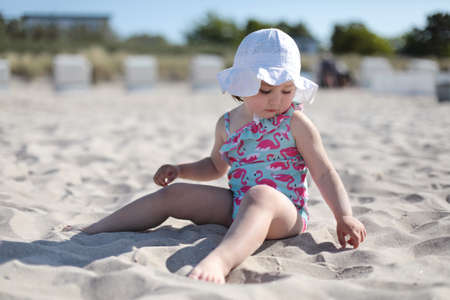 Little happy girl on white sand beach enjoying summer and vacation.の写真素材