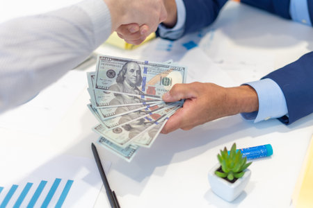 Employees celebrating business success with paper money