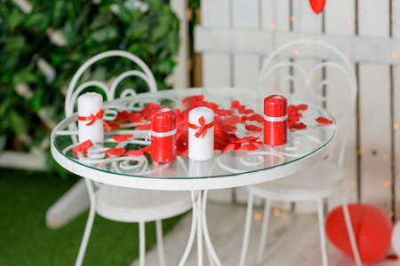 Romantic table with red hearts, rose petals and gift boxの写真素材