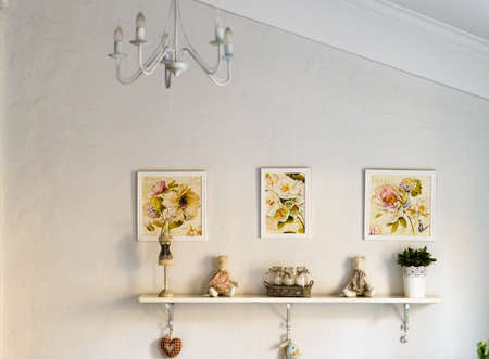 Wall shelf with toys, flowers and pictures on wallの写真素材