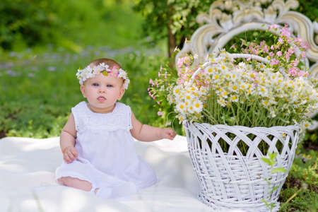 Baby girl outdoors portrait. Sunny Green Summer background. Portrait of beautiful angel girl playing outsideの写真素材