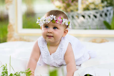 Baby girl outdoors portrait. Sunny Green Summer background. Portrait of beautiful angel girl playing...