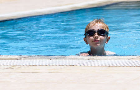 Kid swimming in the pool. Summertime holidays