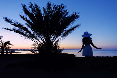Girl silhouette at sunset. Beautiful sea view at sunset. Tropic Island. Cyprus Protarasの写真素材