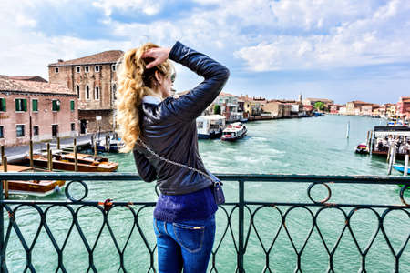 Woman walking in Murano island Italy. Traveler or tourist girl exploring the cityの写真素材