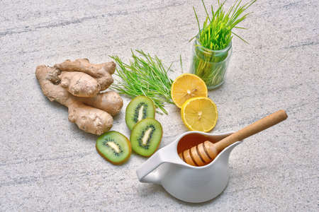 Honey in a pot, Green wheat, lemon and ginger, kiwi for a fresh juice or detox smoothieの写真素材