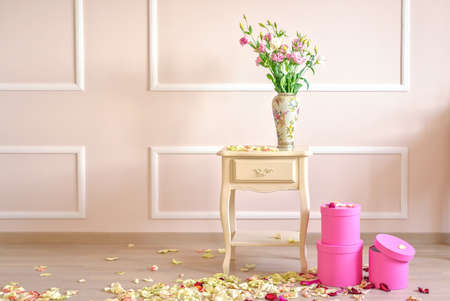 Commode table Flowers and gift boxes in a classic style room. Romantic decorations and petals on the floorの写真素材