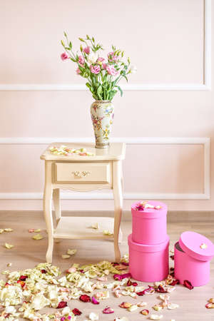 Flowers and gift boxes in a classic style room. Romantic decorations and petals on the floorの写真素材