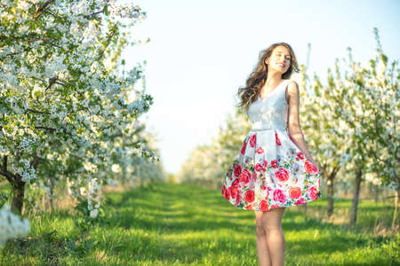 Happy Woman in an orchard at springtime. Enjoying sunny warm day.の写真素材