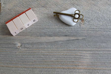 Word love in single wooden letters with heart of stone and metal keyの写真素材