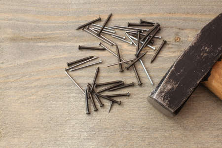 Hammer with nails on wood backgroundの写真素材