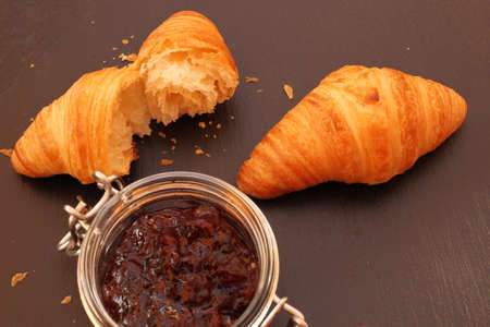French croissant with jam on black backgroundの写真素材