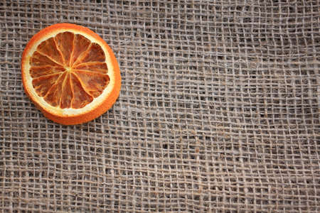 Dried slice of orange on green background with space for your message