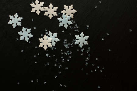 White and blue sugar snowflakes with blue sugar crystals on black backgroundの写真素材