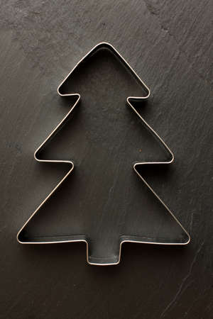 Christmas tree cookie cutter on black backgroundの写真素材