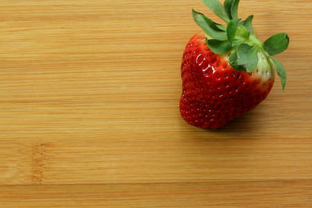 Red, ripe strawberry on bamboo backgroundの写真素材