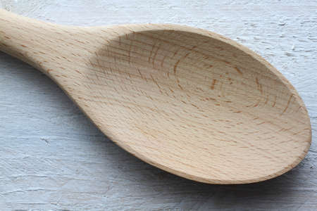 Wooden kitchen trowel on a shabby looking white tableの写真素材