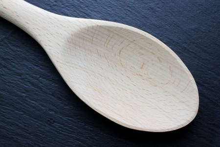 Wooden kitchen trowel on slate boardの写真素材